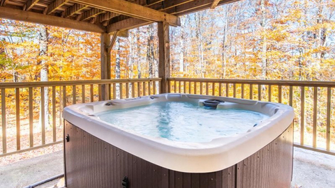 private outdoor hot tub surrounded by autumn trees at 19 middle ridge vacation rental.