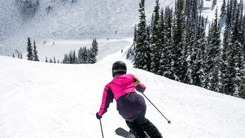 Woman focuses on turns on a groomer. 