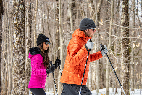 man and women snowshoeing in the woods at stratton on a nordic trail