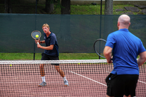 two adults playing doubles at stratton resort’s cliff drysdale tennis center, showcasing on-court action from the adult tennis camp program