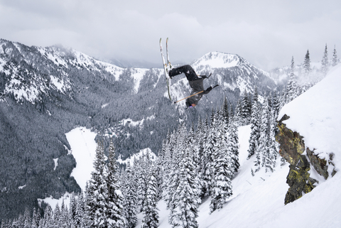 Adult Freerider does a backflip off a large kicker. 