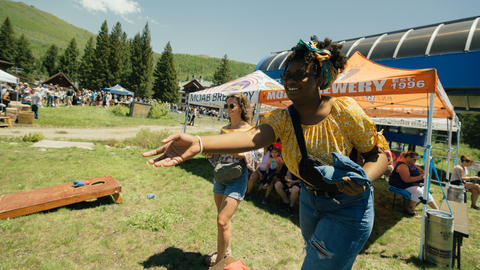 Two friends play cornhole at Big Cottonwood Canyon Brew Fest at Solitude Mountain Resort