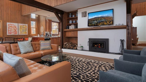 main living area at 19 middle ridge vacation rental featuring wood fireplace, leather sectional, and mounted tv