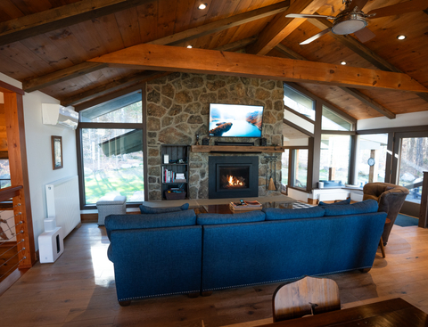 vaulted ceiling living room with stone fireplace and mountain views at 34 saw mill vacation rental at stratton mountain resort
