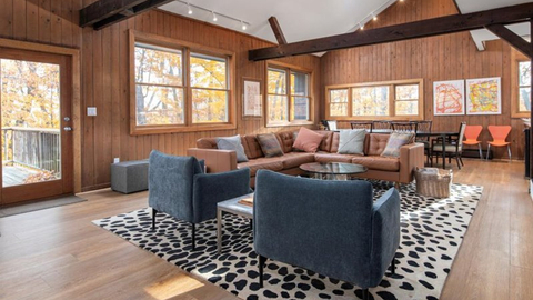 main living area at 19 middle ridge vacation rental featuring wood fireplace, leather sectional, and mounted tv