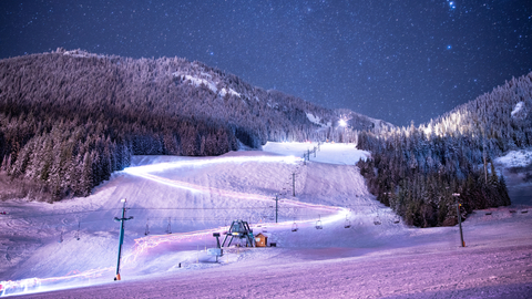 Starry night mountain shot. Lights, purple, night skiing 