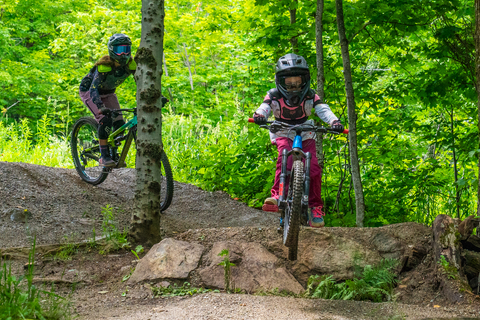 riders with helmets on trails during a mountain biking camp for kids in vermont at stratton mountain resort