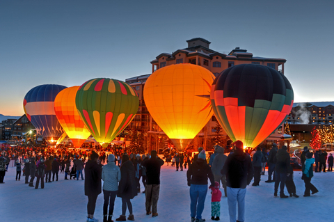 Hot air balloons lit up in evening