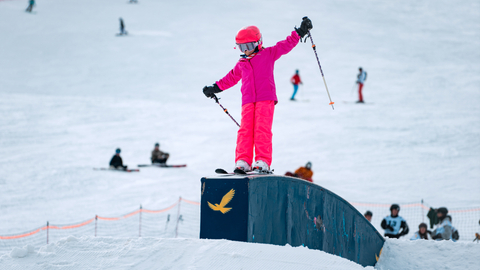 a young skier rides a box in the terrain park at Solitude