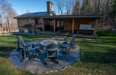 private backyard with adirondack seating and hot tub at 34 saw mill vacation rental at stratton mountain resort