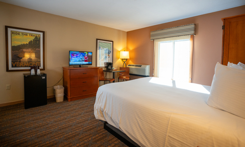 bright hotel guest room with king bed, desk, and large window at black bear lodge located at stratton mountain resort