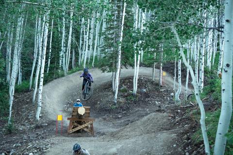 Friends hit a wooden feature on Unleaded at Solitude Bike Park.
