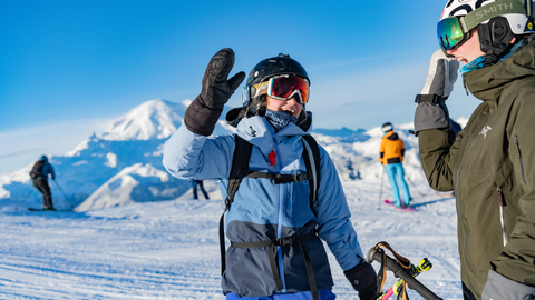 Two snowboarders give each other a high-five