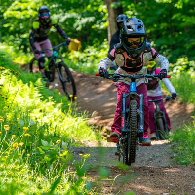 a cyclist enjoys downhill mountain biking on a fast dirt trail at stratton bike park in vermont