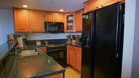 fully equipped kitchen with granite counters and wood cabinetry at landmark 315 vacation rental in stratton mountain resort