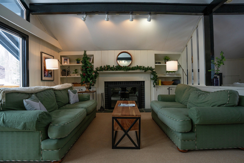 main living room with fireplace and dual green couches at 22 north branch stratton vacation rental