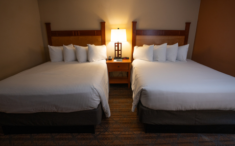 two queen beds with wood headboards in a standard hotel room at black bear lodge located at stratton mountain resort