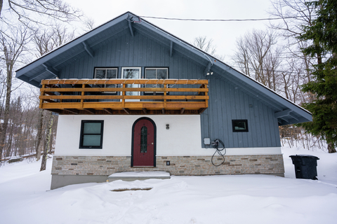 winter view of 22 north branch vacation rental with chalet style roof and red entry door.