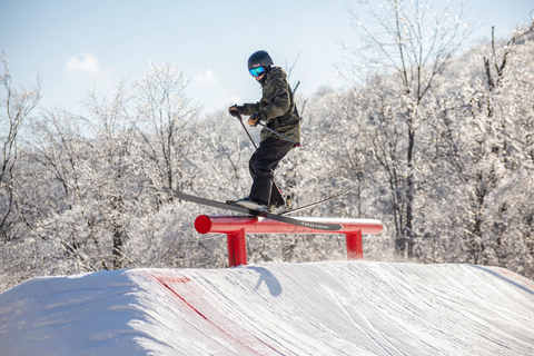 teen skier practicing freestyle skills on a terrain park rail during ski camp at stratton mountain resort