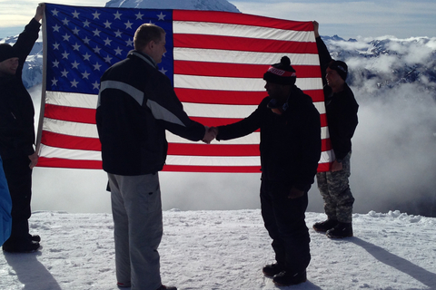 people holding American flag with Rainier in the background