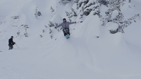 Man skis off a kicker with arms open