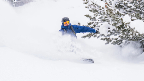 A snowboarder makes powder turns at Solitude Mountain Resort