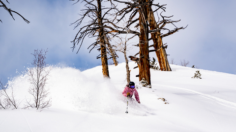 A skier skis powder on an Early Season day while staying at Solitude Mountain Resort.