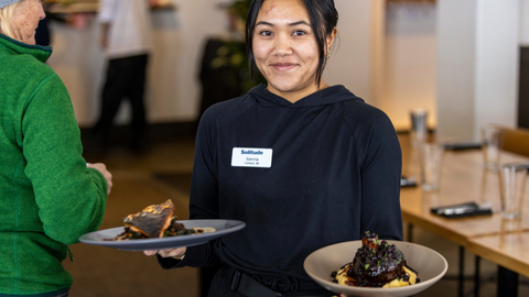 An employee brings lunch to the table at Honeycomb Grill at Solitude Mountain Resort.