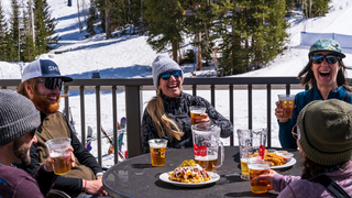 Friends enjoying après beers and appetizers on the rooftop deck of Argenta Pub at Solitude Mountain Resort