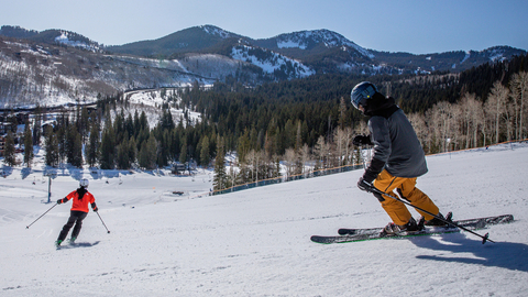 Two skiers make turns on a groomed run at Solitude Mountain Resort