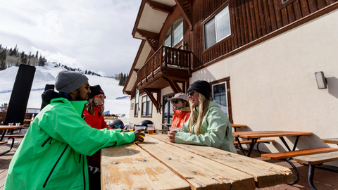 Friends enjoy après outside Last Chance Lodge at Solitude Mountain Resort.