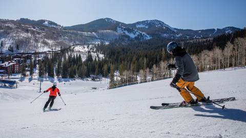 Two skiers make turns on a groomed run at Solitude Mountain Resort